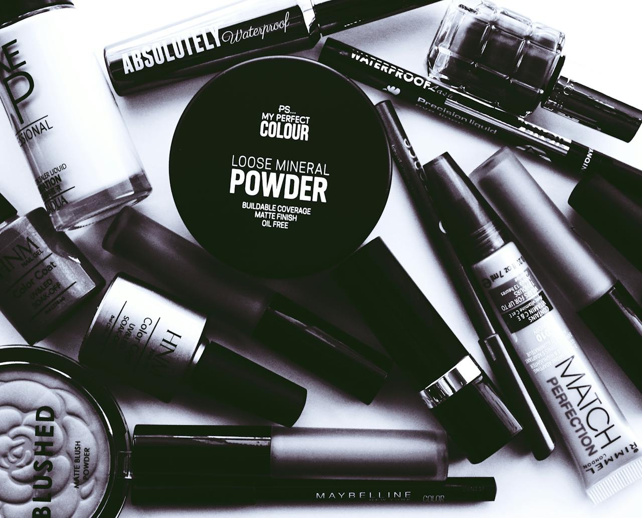 about-01 Elegant monochrome flatlay showcasing a collection of beauty products and cosmetics.